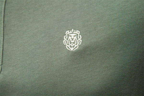 Groene polo met geborduurd wit leeuwembleem, hoogwaardige katoenen stof, stijlvolle herenkleding, perfect voor casual en formele gelegenheden.