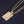 Gouden ketting met rechthoekige hanger en anatomisch hartontwerp, glanzend op zwarte achtergrond. Stijlvolle sieraden voor dames.
