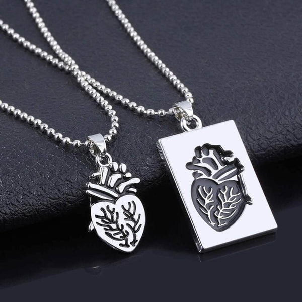 Zilveren anatomisch hartketting en hanger set op zwarte achtergrond, uniek sieraad, moderne stijl, perfect cadeau voor liefhebbers van sieraden.