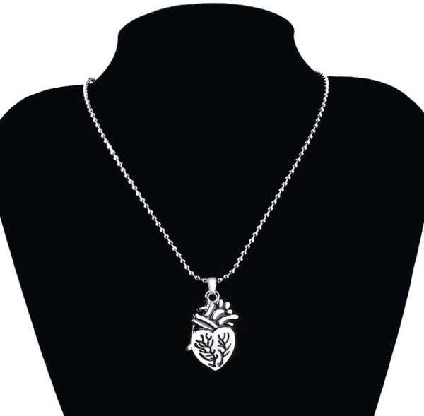 Zilveren hartvormige ketting met gedetailleerd anatomisch hartontwerp op zwarte achtergrond, perfect voor modieuze sieradenliefhebbers.