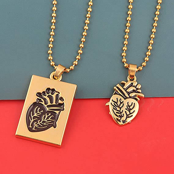 Twee gouden kettingen met anatomisch hart hanger, rechthoekig en hartvormig, op kleurrijke achtergrond. Perfect cadeau, sieraden, modeaccessoire.