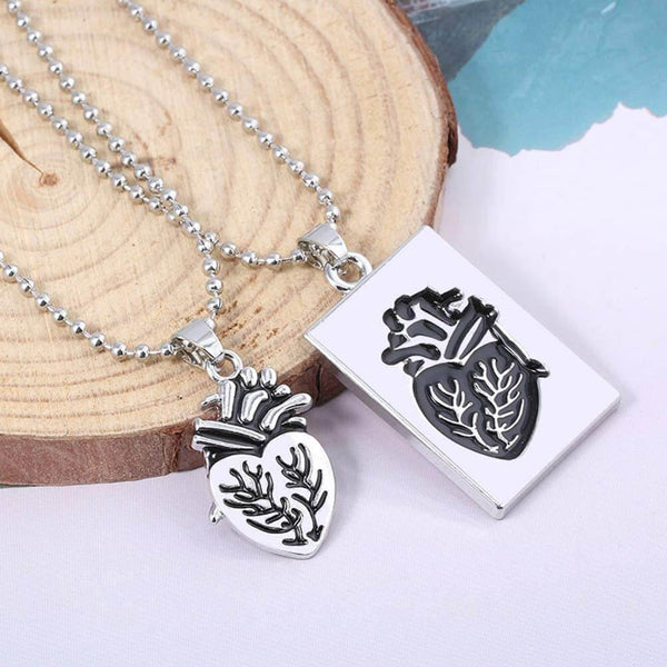 Zilveren anatomisch hartketting en hanger op houten achtergrond, uniek sieraad, cadeau-idee, moderne stijl, symboliek van liefde en leven.