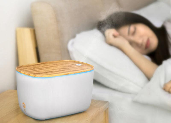 Moderne luchtbevochtiger met houten deksel op nachtkastje, naast slapende vrouw. Stijlvol ontwerp, ideaal voor slaapkamer, luchtkwaliteit verbeteren.