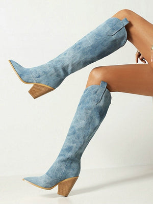 Vrouw met blauwe suède knielaarzen met blokhak, zittend op een stoel. Trendy damesmode, stijlvolle laarzen, casual chique look.