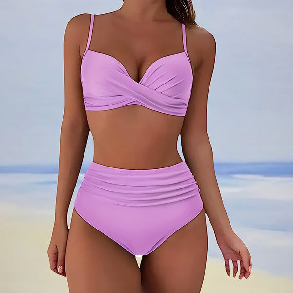 Vrouw in roze bikini met hoge taille, strandachtergrond. Modieuze badmode, zomerstijl, strandkleding, dames zwemkleding.