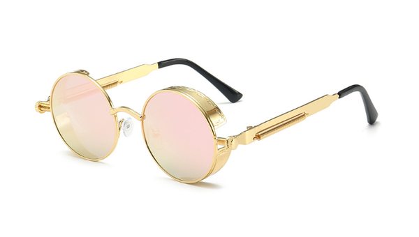 Gouden ronde zonnebril met roze getinte glazen en zwarte pootjes, retro stijl, unisex design, modieuze accessoire voor zomer en festival.