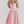Vrouw in roze vintage jurk met korset en wijde rok, elegante mode, studioportret, trendy dameskleding, stijlvolle outfit, modefotografie.