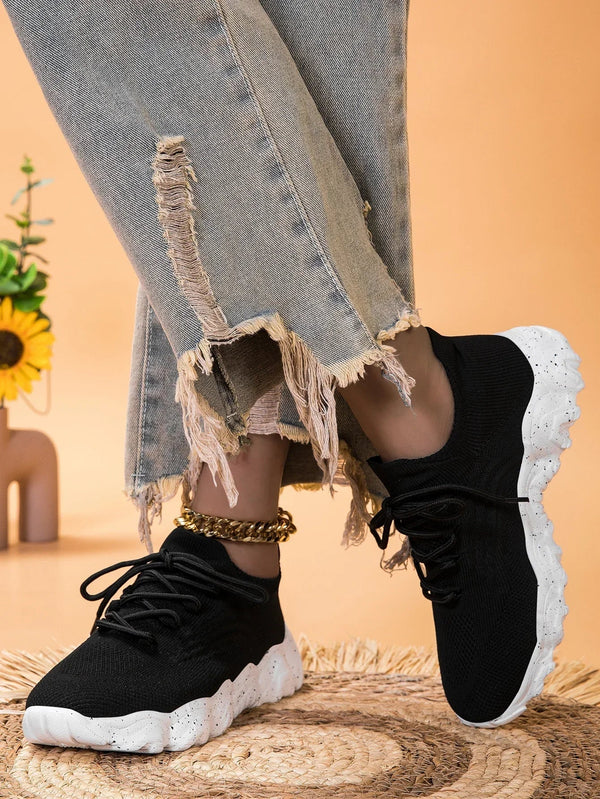 Zwarte sneakers met witte zool, gedragen met gerafelde jeans. Stijlvolle casual schoenen voor dames, perfect voor dagelijks gebruik en modebewuste outfits.
