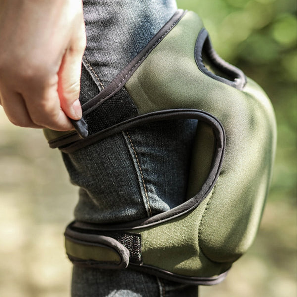 Groene kniebeschermer met klittenbandsluiting, gedragen op een spijkerbroek. Ideaal voor tuinieren en kniebescherming. Comfortabel en duurzaam ontwerp.