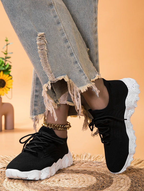 Zwarte sneakers met witte zool, gedragen met gerafelde jeans. Stijlvolle casual schoenen voor dames, perfect voor dagelijks gebruik en modebewuste outfits.