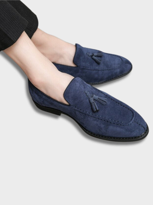 Blauwe Italiaanse loafers van suède met kwastjes, gedragen door een persoon. Stijlvolle herenschoenen, ideaal voor formele en casual outfits.