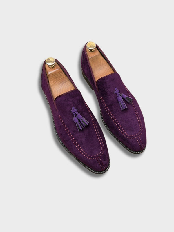 Paarse Italiaanse loafers van suède met kwastjes, houten schoenspanners, luxe herenschoenen, Florence stijl, op witte achtergrond.