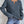 Grijze gebreide damestrui met V-hals, gedragen met lichtblauwe jeans. Modieuze herfstkleding, casual stijl, comfortabele pasvorm.