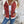 Vrouw in casual outfit met witte trui en rode spijkerjasje, blauwe jeans. Stijlvolle mode, herfstkleding, trendy dameskleding.