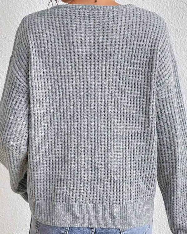 Grijze gebreide trui dames, rugaanzicht. Zachte textuur, casual stijl, perfect voor herfst- en wintermode. Comfortabele pasvorm, trendy design.