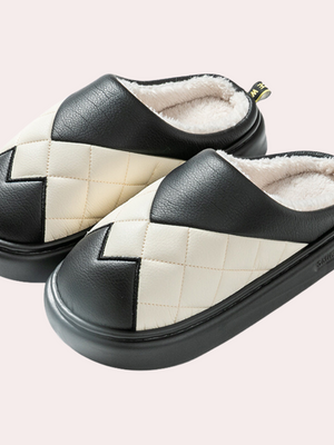 Zwart-witte pantoffels met gewatteerd ruitpatroon en zachte voering, ideaal voor wintercomfort. Stijlvolle en warme huisschoenen voor dagelijks gebruik.