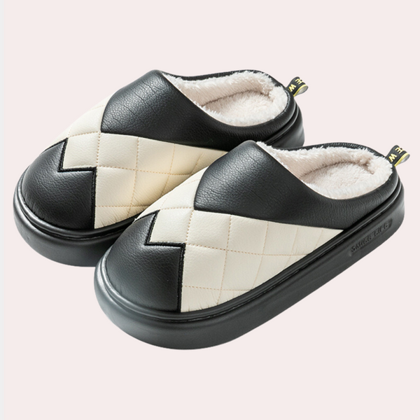 Zwart-witte pantoffels met gewatteerd ruitpatroon en zachte voering, ideaal voor wintercomfort. Stijlvolle en warme huisschoenen voor dagelijks gebruik.