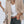 Vrouw in stijlvolle khaki blazer, witte top en donkere jeans, met beige tas. Modieuze zakelijke outfit, perfect voor casual en professionele gelegenheden.