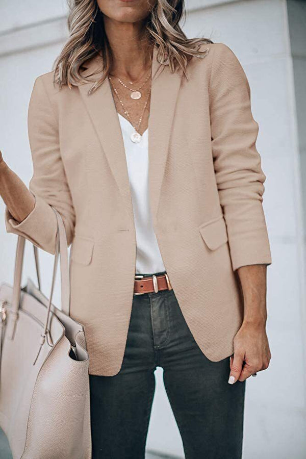 Vrouw in stijlvolle khaki blazer met witte blouse en zwarte broek, draagt een beige handtas. Mode, dameskleding, zakelijke outfit.