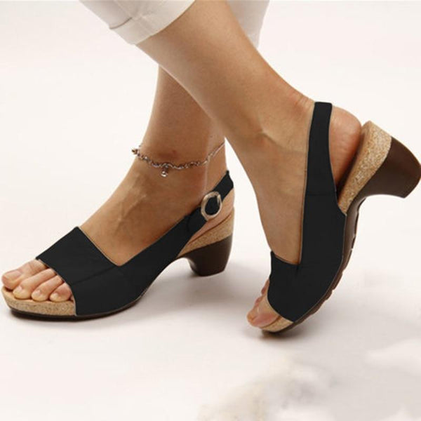 Zwarte orthopedische sandalen met stevige hak, open teen en verstelbare band, gedragen door vrouw. Comfortabele en elegante zomerschoenen.