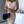 Beige geribde jurk, vrouw, zwarte designer handtas, moderne interieur, mode, elegantie, stijlvolle outfit, trendy kleding, luxe accessoires.