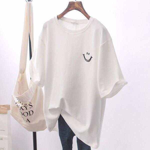 Witte dames T-shirt met lachend gezichtje, casual stijl, korte mouwen, katoenen stof, op houten hanger, naast beige tas.