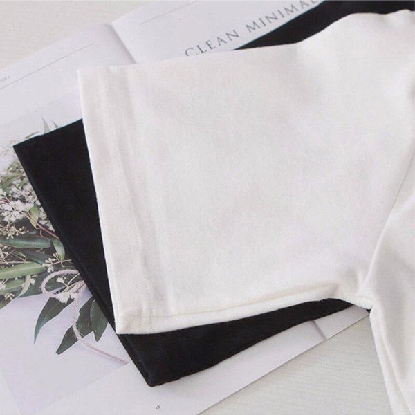 Witte en zwarte T-shirts op een open tijdschrift, minimalistisch design, katoenen stof, damesmode, casual kleding, trendy basics.