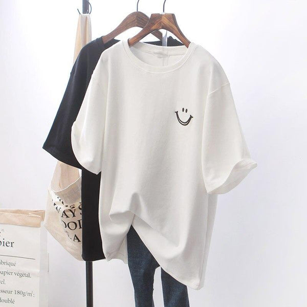 Twee T-shirts op hangers, wit en zwart, met smiley opdruk. Casual damesmode, katoenen T-shirts, minimalistisch ontwerp, trendy kleding.