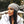 Vrouw met grijze beanie en witte winterjas met bontkraag, buiten in een herfstlandschap. Stijlvolle wintermode, trendy accessoires, herfstkleding.
