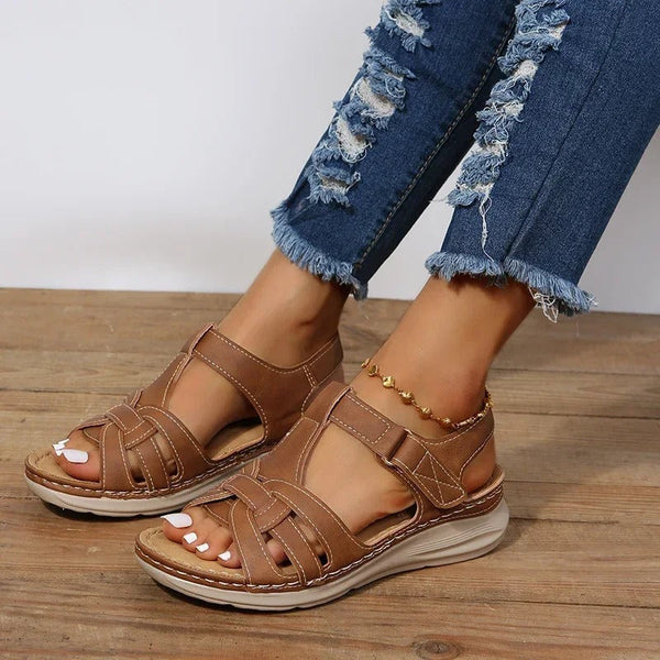 Bruine leren sandalen voor dames, gedragen met gescheurde jeans. Comfortabele zomerschoenen, ideaal voor casual en trendy outfits.