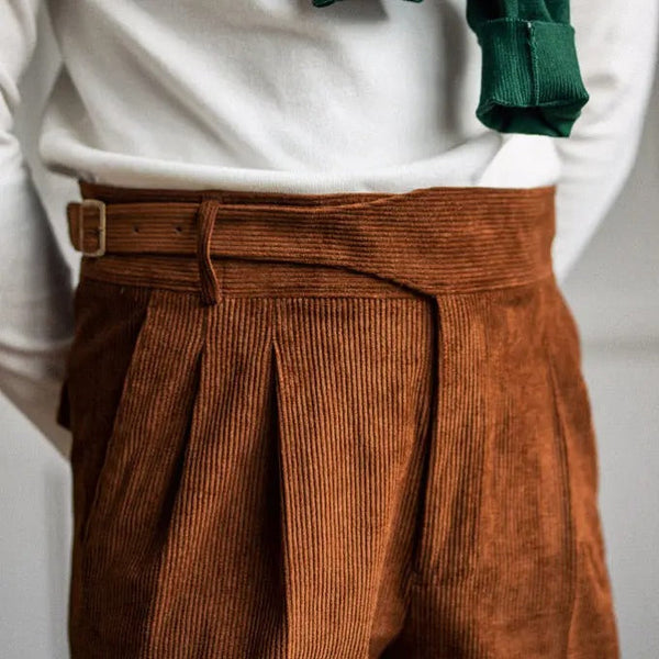 Bruine corduroy broek met hoge taille en plooien, gedragen met witte trui. Modieuze herenkleding, herfststijl, comfortabele pasvorm.