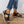 Zwarte dames sandalen met klittenband, comfortabele zool, gedragen met gerafelde jeans op houten vloer. Perfect voor casual zomeroutfits.