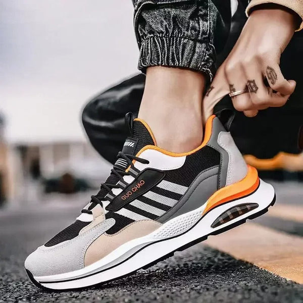 Moderne zwart-grijze sportschoen met oranje accenten, ademend mesh, en stevige zool. Perfect voor hardlopen en casual streetwear.