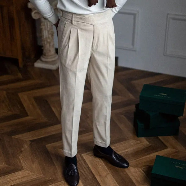 Beige pantalon voor heren, elegant geplooid, gedragen met zwarte loafers. Perfect voor formele gelegenheden. Stijlvolle herenkleding.