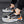 Zwart-grijze sportschoenen met oranje accenten, ademend mesh, en dempende zool. Ideaal voor hardlopen en casual gebruik. Unisex sneakers.