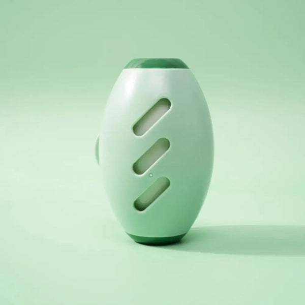 Groene, ovale luchtverfrisser met drie openingen op een mintgroene achtergrond. Modern design, ideaal voor huisgeurverbetering en interieurdecoratie.