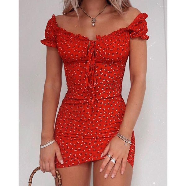 Rode off-shoulder zomerjurk met bloemenprint, korte mouwen en strikdetail, gedragen door vrouw. Perfect voor zomerse mode en casual outfits.