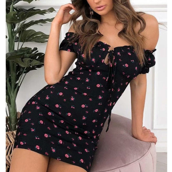 Vrouw in off-shoulder zomerjurk met bloemenprint, rood en zwart, elegante stijl, modetrend, casual chique, geschikt voor zomerse gelegenheden.