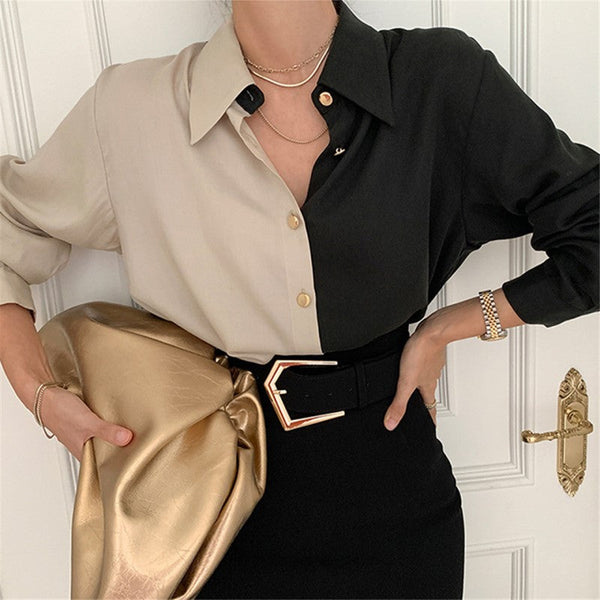 Oversized blouse voor dames, beige en zwart, met gouden knopen en schoudervulling. Stijlvol design, perfect voor modieuze outfits.