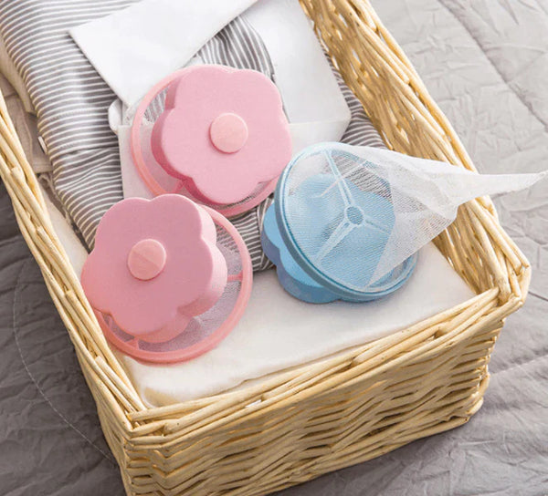 Rieten mand met roze en blauwe wasmachine pluizenfilters in bloemvorm, ideaal voor het verwijderen van haren en pluisjes uit kleding.