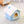 Blauw pluche hondenhuisje op witte tapijt, met zacht dak en ronde opening. Perfect voor huisdierencomfort en interieurdecoratie.