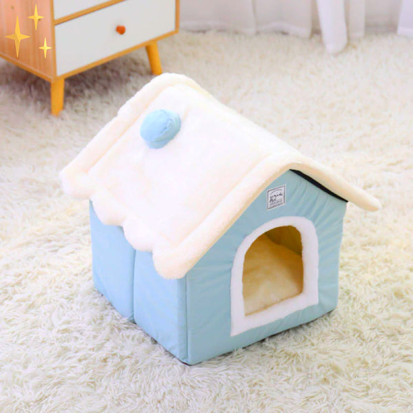 Blauw pluche hondenhuisje op witte tapijt, met zacht dak en ronde opening. Perfect voor huisdierencomfort en interieurdecoratie.