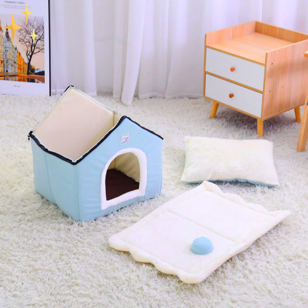 Blauwe hondenmand in huisvorm op witte tapijt, met kussen en houten kastje. Perfect voor huisdieren, stijlvol en comfortabel interieur.