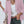 Vrouw in roze blazer met witte top en groene broek, draagt beige tas. Modieuze dameskleding, casual chic stijl, trendy outfit.