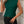 Vrouw in groene mouwloze top met geometrisch patroon, zwarte jeans, drinkt koffie. Modieuze dameskleding, casual stijl, stedelijke achtergrond.