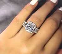 Diamanten verlovingsring met rechthoekige steen en pavéband op hand. Luxe sieraden, trouwring, elegante diamant, glanzend juweel.