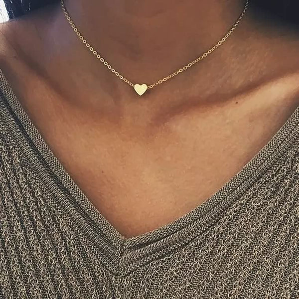 Gouden hartvormige ketting op vrouwelijk decolleté, minimalistisch ontwerp, perfect voor dagelijks gebruik en cadeau-ideeën.