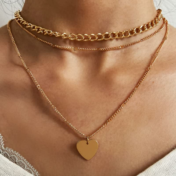 Gouden kettingen met hartvormige hanger, gelaagd op de hals van een vrouw. Trendy sieraden, modieuze accessoires, elegante uitstraling.