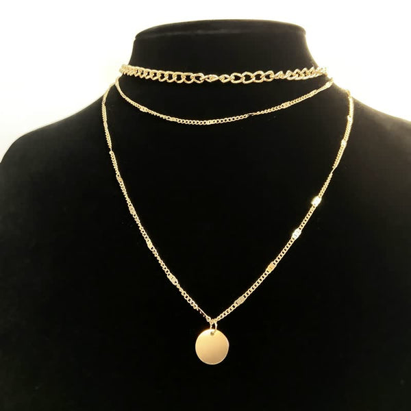 Gouden ketting met ronde hanger en dubbele schakelketting op zwarte achtergrond. Stijlvolle damesaccessoire, perfect voor modieuze sieraden.