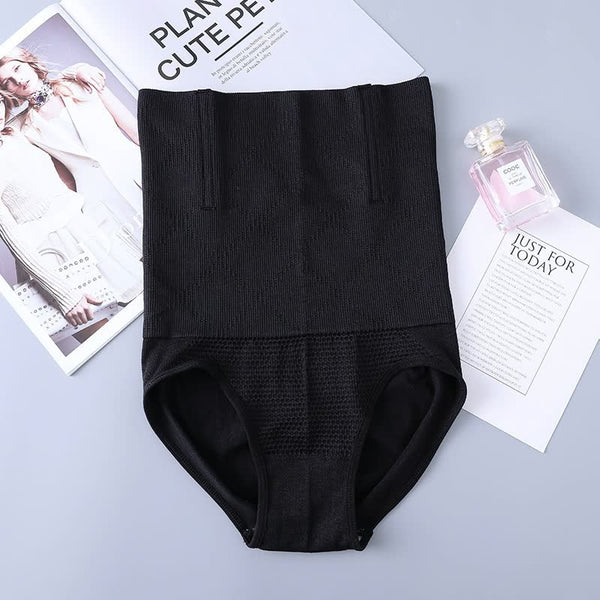 Zwarte corrigerende slip op grijze achtergrond, naast tijdschrift en parfumfles. Shapewear, damesmode, slankmakend ondergoed.